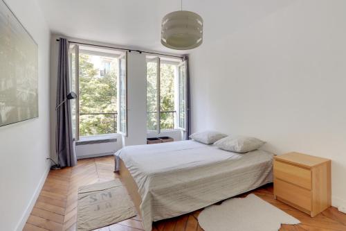 パリにあるThe BEST DEAL in the MARAIS - 1Bedroom Apt - 45m2の白いベッドルーム(ベッド1台、窓2つ付)