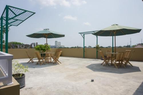 a patio with tables and umbrellas on a roof at RedDoorz Syariah near Taman Pelangi Monjali in Yogyakarta