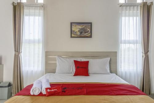 a bedroom with a bed with red and white pillows at RedDoorz Syariah near Taman Pelangi Monjali in Yogyakarta