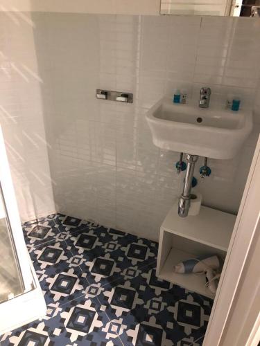a white bathroom with a sink and a shower at Hostal Ciempozuelos, cerca del Parque Warner y Madrid in Ciempozuelos
