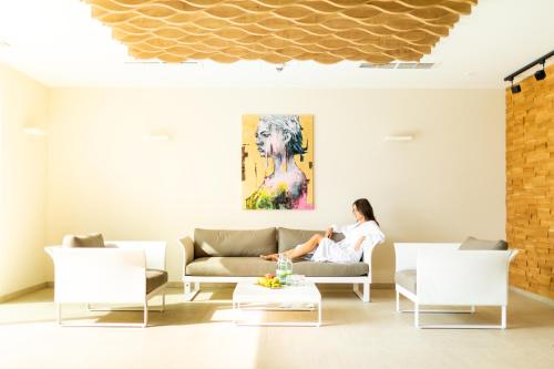 a woman sitting on a couch in a living room at Schwan und Post Business Quarters in Bad Neustadt an der Saale