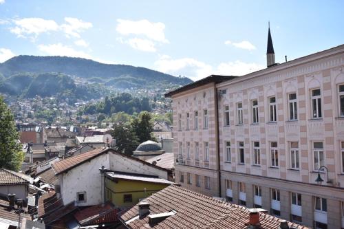 Blick auf eine Stadt mit Gebäuden und Bergen in der Unterkunft Garni Hotel Konak in Sarajevo