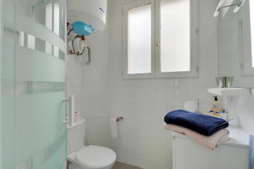 une salle de bain blanche avec toilettes et fenêtre dans l'établissement The BEST DEAL in the MARAIS - 1Bedroom Apt - 45m2, à Paris