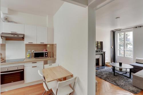 d'une cuisine et d'un salon avec des placards blancs et une table. dans l'établissement The BEST DEAL in the MARAIS - 1Bedroom Apt - 45m2, à Paris