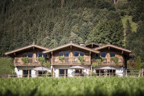a large wooden house with balconies on a mountain at Zillertaler Hofchalets in Stumm
