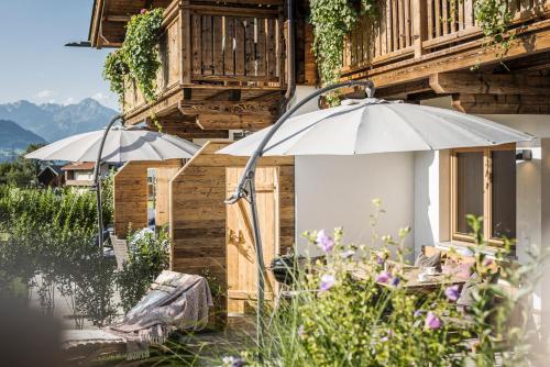 two white umbrellas sitting outside of a building at Zillertaler Hofchalets in Stumm