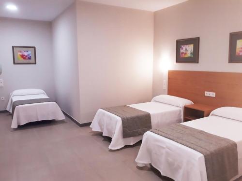 a hospital room with three beds in a room at Hostal Montemayor in Moguer