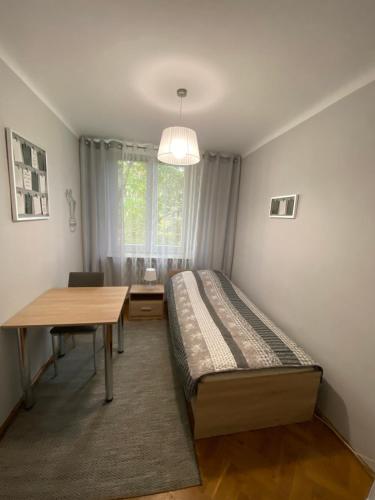 a bedroom with a bed and a table and a window at Chrobrego 4 in Biała Podlaska
