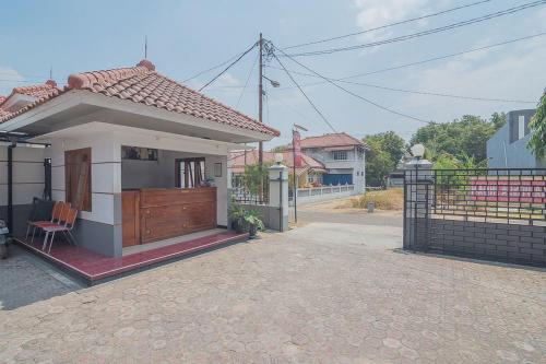 a small house with a porch and a fence at RedDoorz Plus near RSUD Majalengka in Majalengka