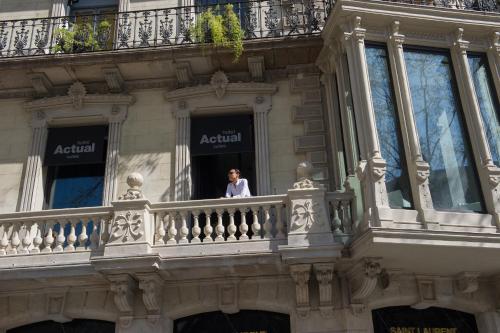 a man is looking out the window of a building at Hotel Actual in Barcelona