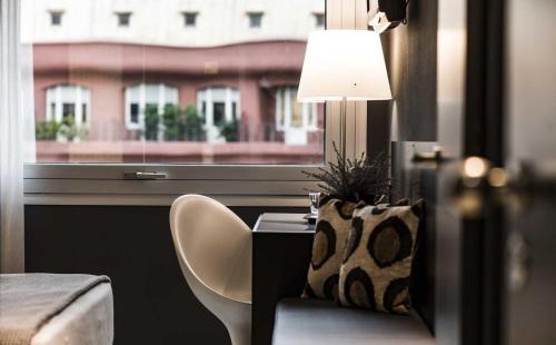 a room with a table and a chair and a window at Hotel Actual in Barcelona