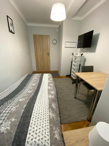 a bedroom with a bed and a table and a desk at Chrobrego 4 in Biała Podlaska