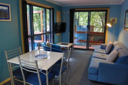 a living room with a couch and a table and chairs at Strahan Bungalows in Strahan