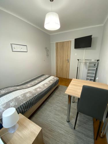 a room with a bed and a table and a television at Chrobrego 4 in Biała Podlaska