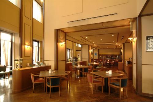 a restaurant with tables and chairs in a room at Hotel Crescent Asahikawa in Asahikawa