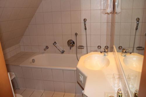 a bathroom with two sinks and a bath tub at Gästehaus Wild in Oberasbach