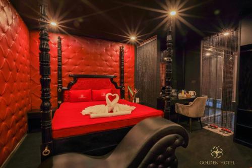 a bedroom with a red bed with a rabbit on it at Golden Hotel in Hanoi