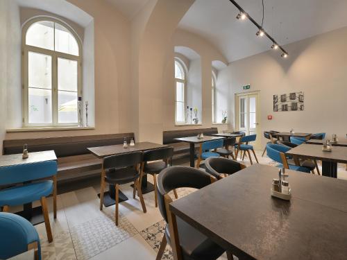 a restaurant with tables and chairs and windows at EA Hotel New Town in Prague