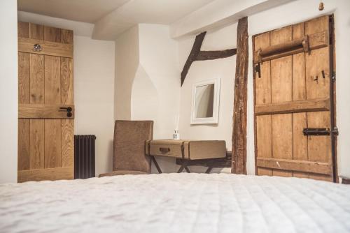 a bedroom with a bed and a desk and doors at B&Bat no3 in Market Bosworth