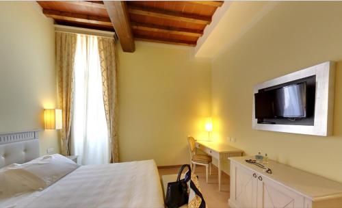 a hotel room with a television and a bed at Hotel Certaldo in Certaldo
