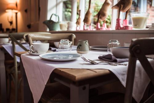a table with a white table cloth on a table with dishes at B&Bat no3 in Market Bosworth
