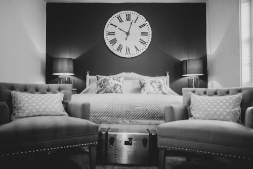 a bedroom with a bed with a large clock on the wall at B&Bat no3 in Market Bosworth