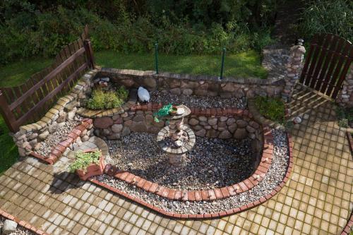a garden with a fence and a stone wall at Grisli house in Gauja