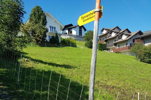 a yellow street sign on a pole next to a fence at Haus Casetta - CharmingStay in Flumserberg