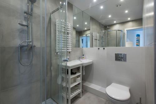 a bathroom with a sink and a shower and a toilet at Komfortowe apartamenty w centrum Wrocławia in Wrocław