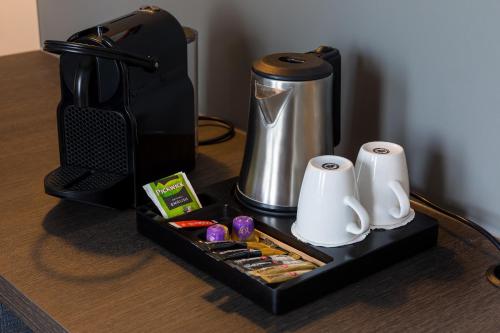 a black tray with a coffee maker and some food at Postillion Hotel Amsterdam in Amsterdam