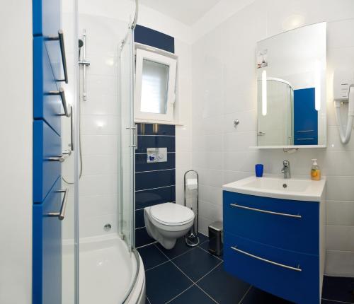 un bagno con WC, lavandino e doccia di Apartmani Gavran a Sevid