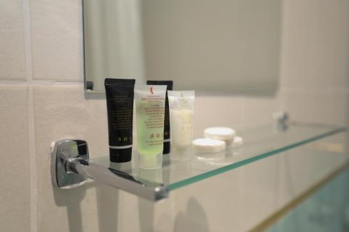 a glass shelf with products on it in a bathroom at Golders Park Hotel in London