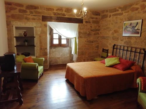 La Posada de Pedrazales في Pedrazales: غرفة نوم بسرير وطاولة وكراسي