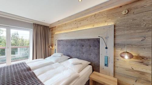 a bedroom with a large bed with white sheets at Sporthotel Leweck in Lipperscheid