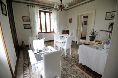 a dining room with white tables and white chairs at il Motto di Tommy in Castelveccana