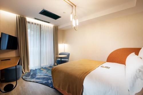 a hotel room with a bed and a television at Mercure Istanbul Bakirkoy in Istanbul