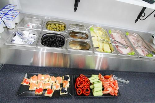 uma geladeira com uma bandeja contendo diferentes tipos de alimentos em Avenue Parliament Old Town - Avenue Hotels em Bucareste