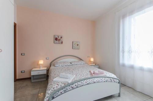 een slaapkamer met een bed met 2 tafels en een raam bij Residenza Leon D'oro in Venetië