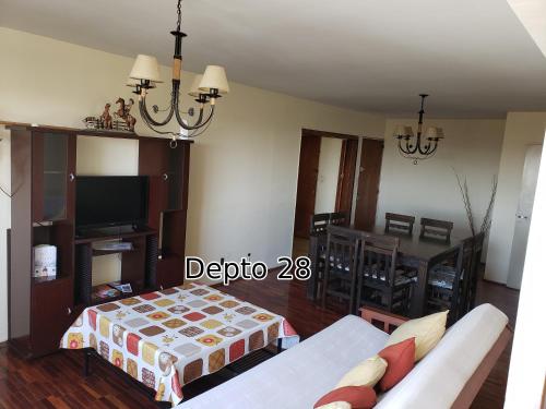 een woonkamer met een bank en een tv bij Departamento Amplio Mendoza Centro, con cochera in Mendoza