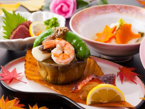 a plate of food with shrimp and vegetables and a bowl of soup at Yamabiko Ryokan in Minamioguni