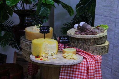 a group of cheeses and other foods on a table at AJ Hotel Chapecó - Fácil Acesso Pátio Shopping e Rótula da Bandeira in Chapecó
