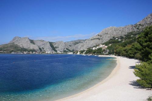 a view of a beach with mountains in the background at Tourist Settlement Brzet in Omiš