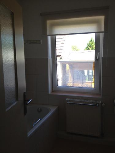 a bathroom with a window and a bath tub at Ferienwohnung Ostseeblick in Insel Poel