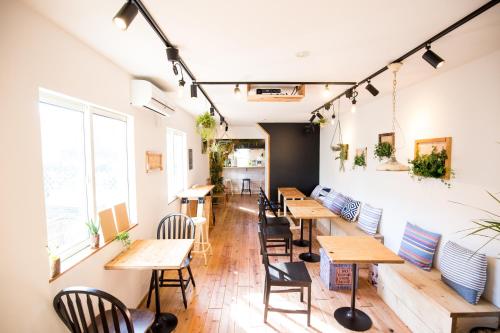 a row of tables and chairs in a restaurant at IZA Enoshima Guest House and Bar in Fujisawa