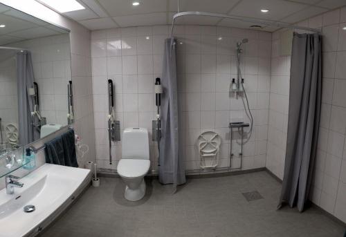 a bathroom with a toilet and a shower and a sink at Hotel Stensson in Eslöv