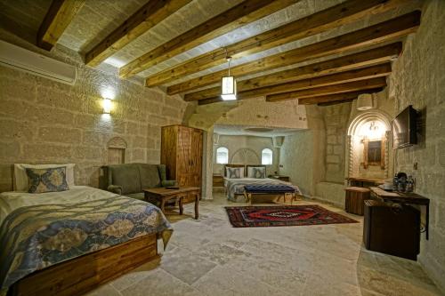 a bedroom with a bed and a living room at Risus Cave Suites in Goreme