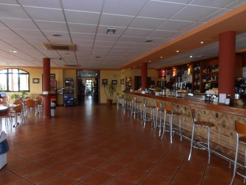 a bar in a restaurant with chairs and a counter at Hotel Cañada Real in Villalpando