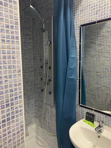 łazienka z umywalką i prysznicem z lustrem w obiekcie Hostal Alcobia w Sewilli