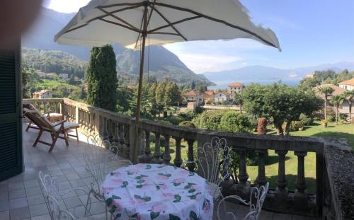 a balcony with a table and an umbrella at il Motto di Tommy in Castelveccana