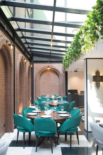 a restaurant with a long table and green chairs at Emens hotel in Izmir